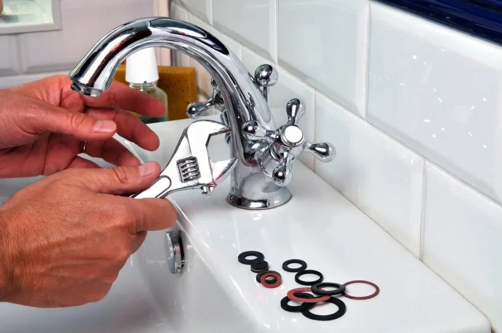 Plumber performing maintenance on a bathroom faucet in Battleground
