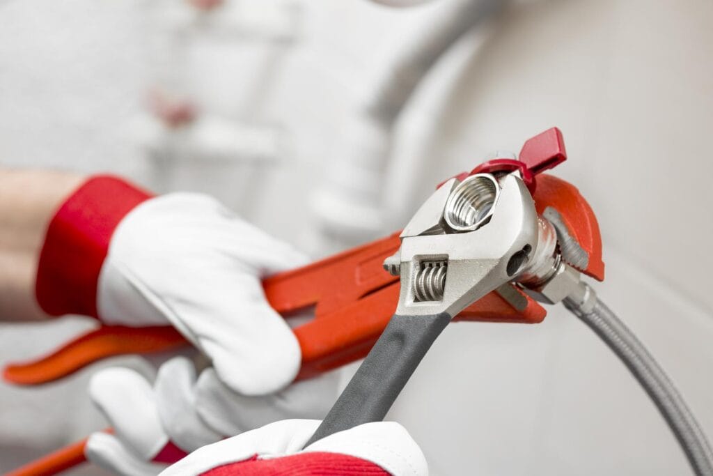 Plumber holding pipe wrenches for an emergency repair in Battleground