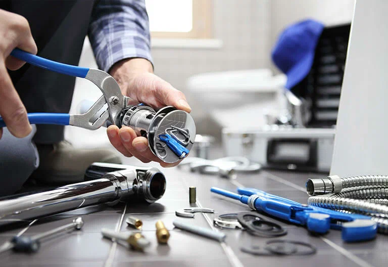 Technician repairing a plumbing fixture with professional tools in Battleground