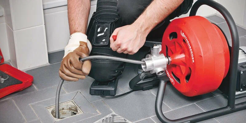 Plumber using a drain-cleaning machine in Battleground