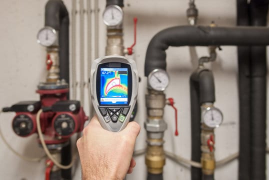 Plumber using a thermal imaging camera to inspect pipes in Battleground