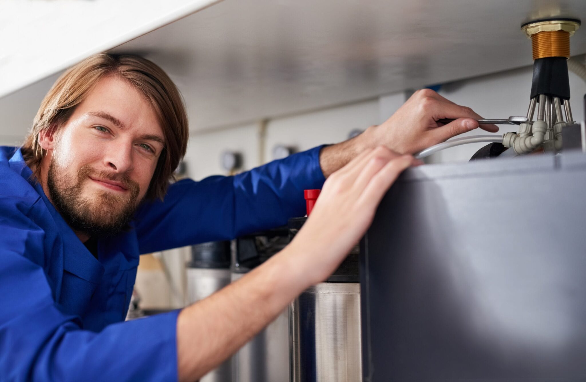Technician servicing a residential water heater tank in Battleground